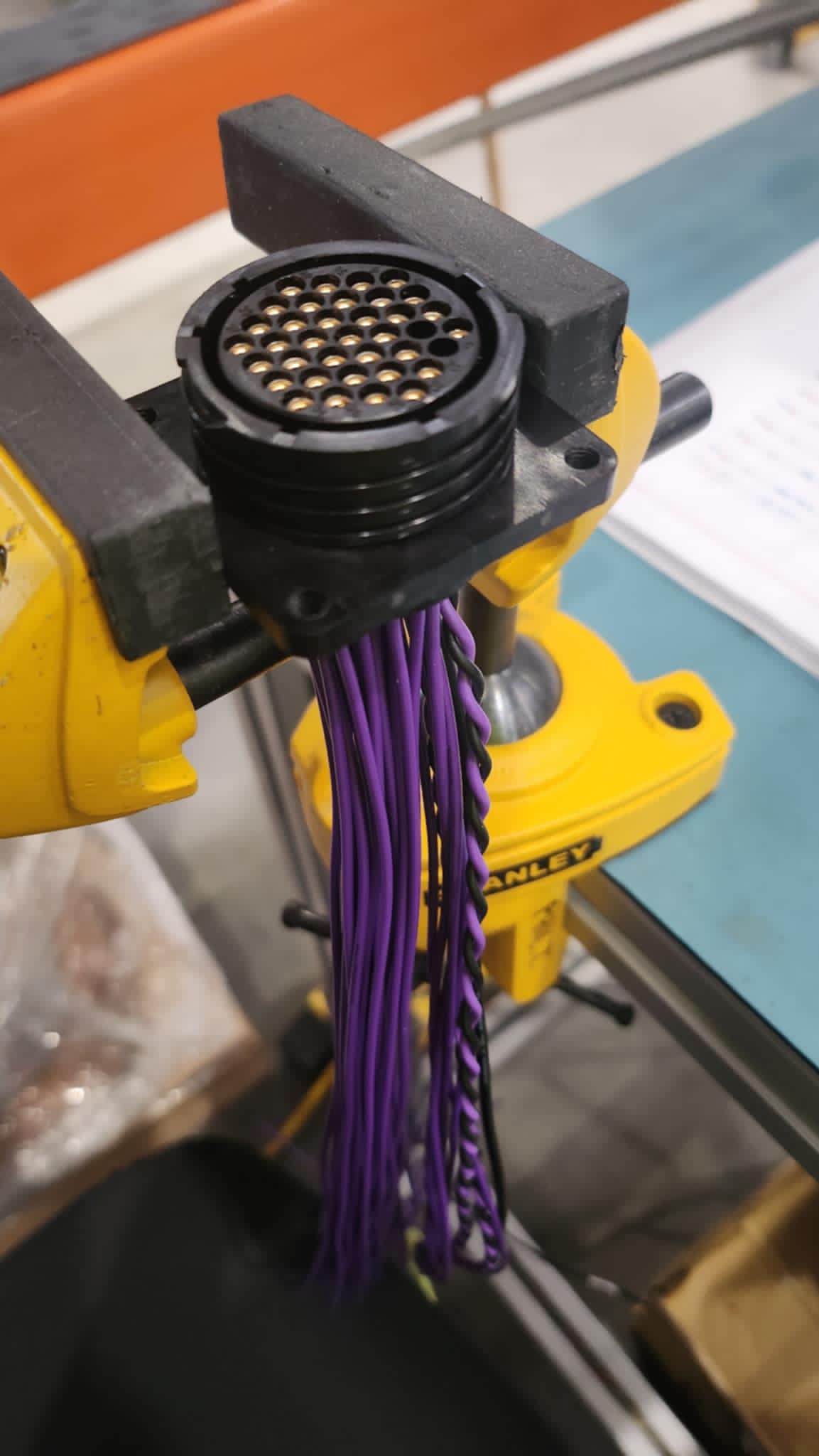Close-up of a multi-pin circular connector with purple automotive wires, built for Control Cables Australia’s industry-standard harness systems.