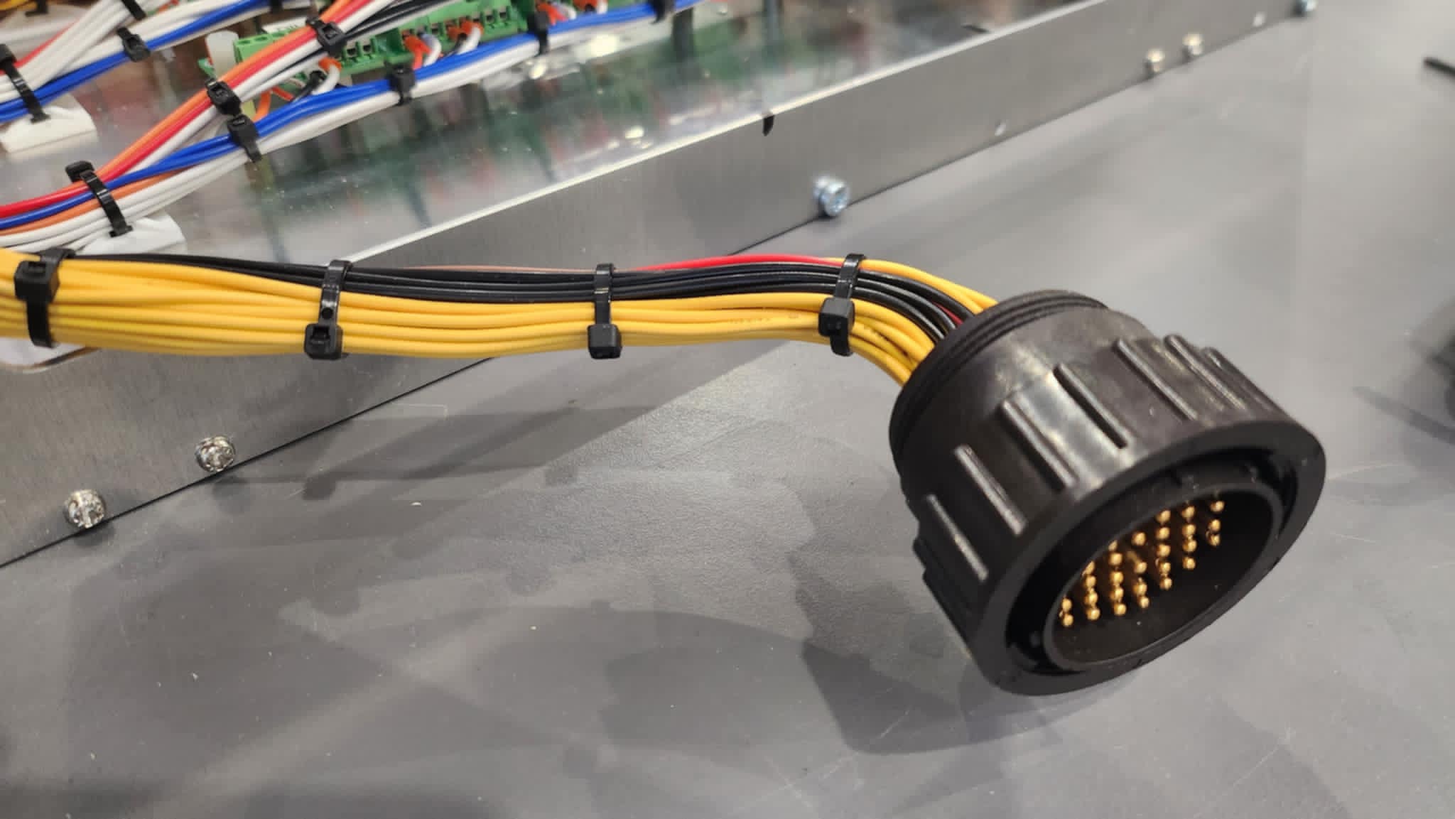 Yellow and black cable harness assembly fitted into a circular connector, showcasing Control Cables Australia’s automotive and industry applications.